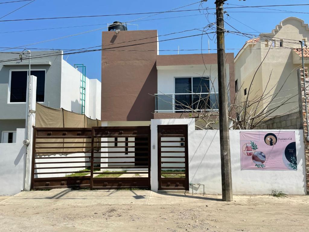 um edifício com um portão em frente a uma casa em Casa SOL em Cobos