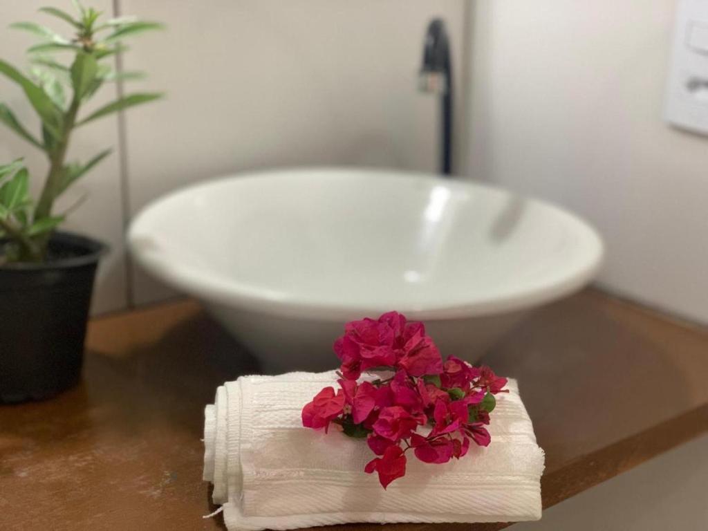 a white sink and a towel with flowers on it at Pousada Toca da Coruja Jeri in Jericoacoara