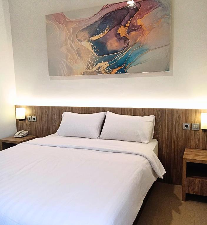 Postel nebo postele na pokoji v ubytování The Safiina Point Syariah Hotel
