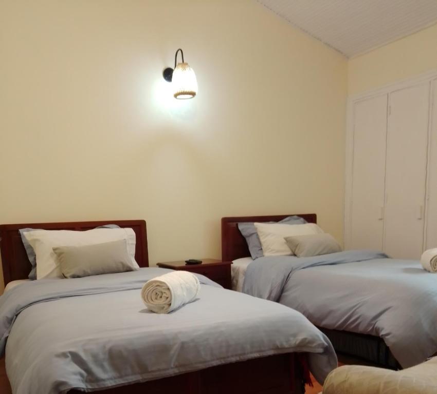 ボゴタにあるBioelemental hotel sustentable Bogotáのベッドルーム1室(ベッド2台付)、壁に照明が備わります。
