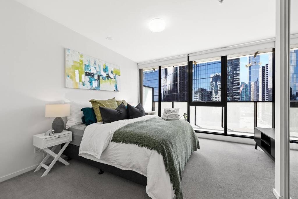 een slaapkamer met een groot bed en grote ramen bij 1BR APT Albert Lake& Crown& DFO& MEC in Melbourne