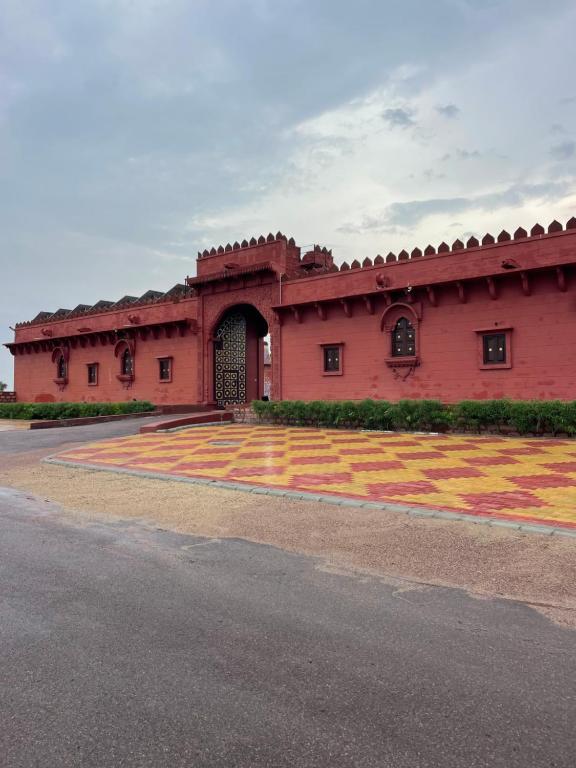 un gran edificio rojo con un gran patio en Pukhraj Garh- A Heritage Homestay, en Jodhpur