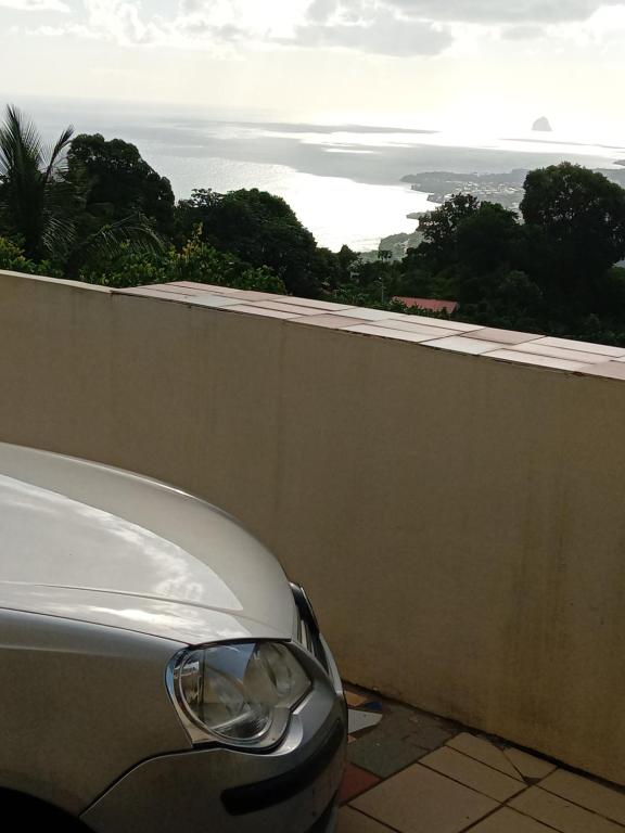 a white car parked next to a wall at Les palmiers in Le Marin