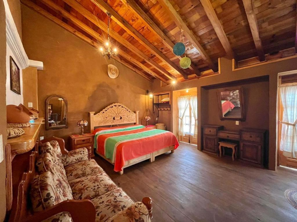 a bedroom with a bed and a couch in a room at Casa del Sol in Pátzcuaro