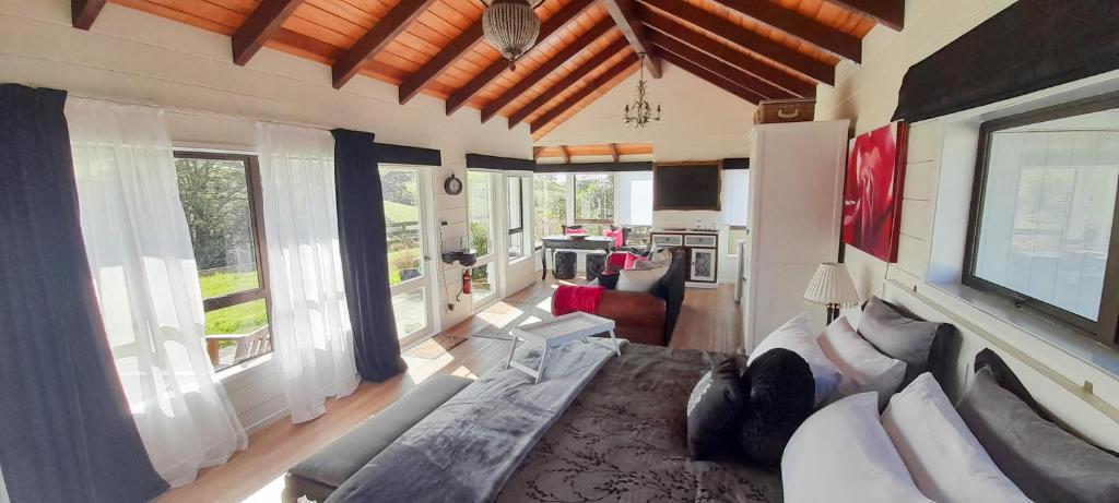 ein großes Wohnzimmer mit einem Sofa und einem TV in der Unterkunft Wharfe Cottage in Wellsford