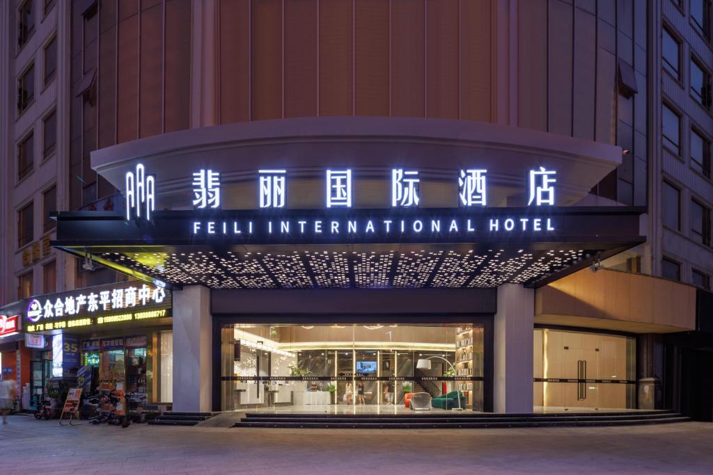un bâtiment avec un panneau indiquant un hôtel international accueillant dans l'établissement Feili International Hotel, à Canton