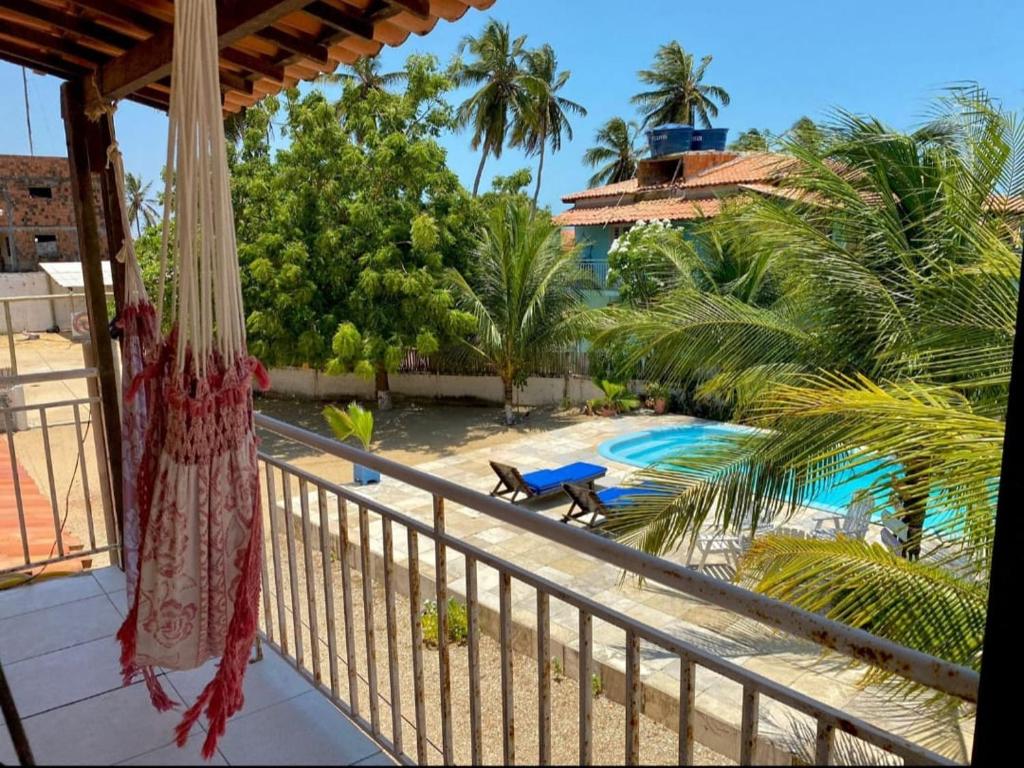 a balcony with a view of a pool and palm trees at Pousada Recanto dos Parente - Icaraizinho de Amontada in Amontada