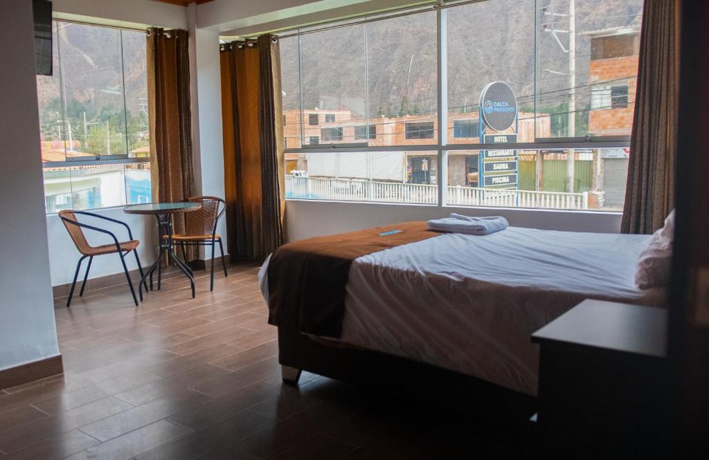 a hotel room with a bed and a large window at Calca Paradise in Calca