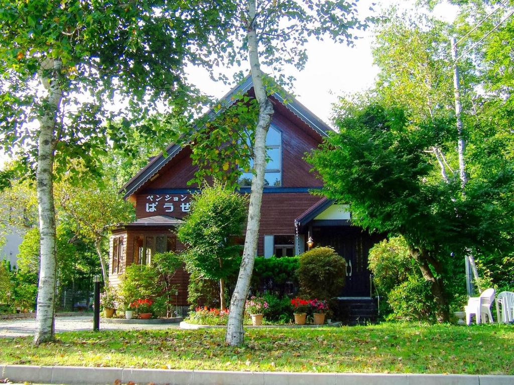 a house with a gambrel roof with flowers and trees at Minamitsuru-gun - Hotel / Vacation STAY 45535 in Yamanakako