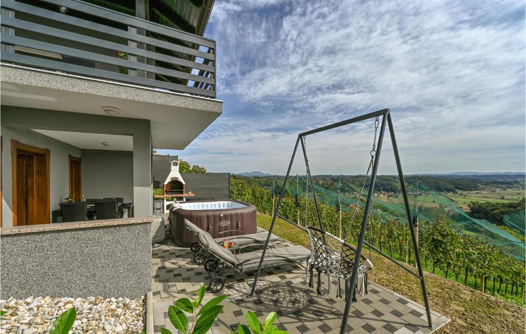 a patio with a swing and a view of a vineyard at Beautiful Home In Veliko Trgovisce With Kitchen in Veliko Trgovišće