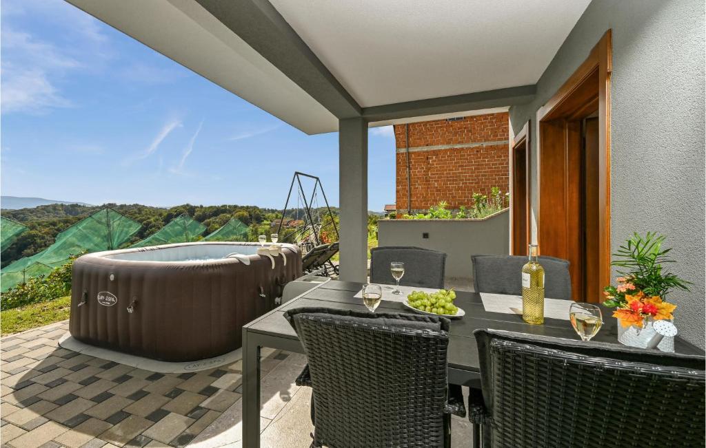 a patio with a hot tub and a table and chairs at Beautiful Home In Veliko Trgovisce With Kitchen in Veliko Trgovišće