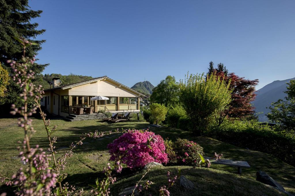 a house with a garden and flowers in front of it at Casa Calina in Carona