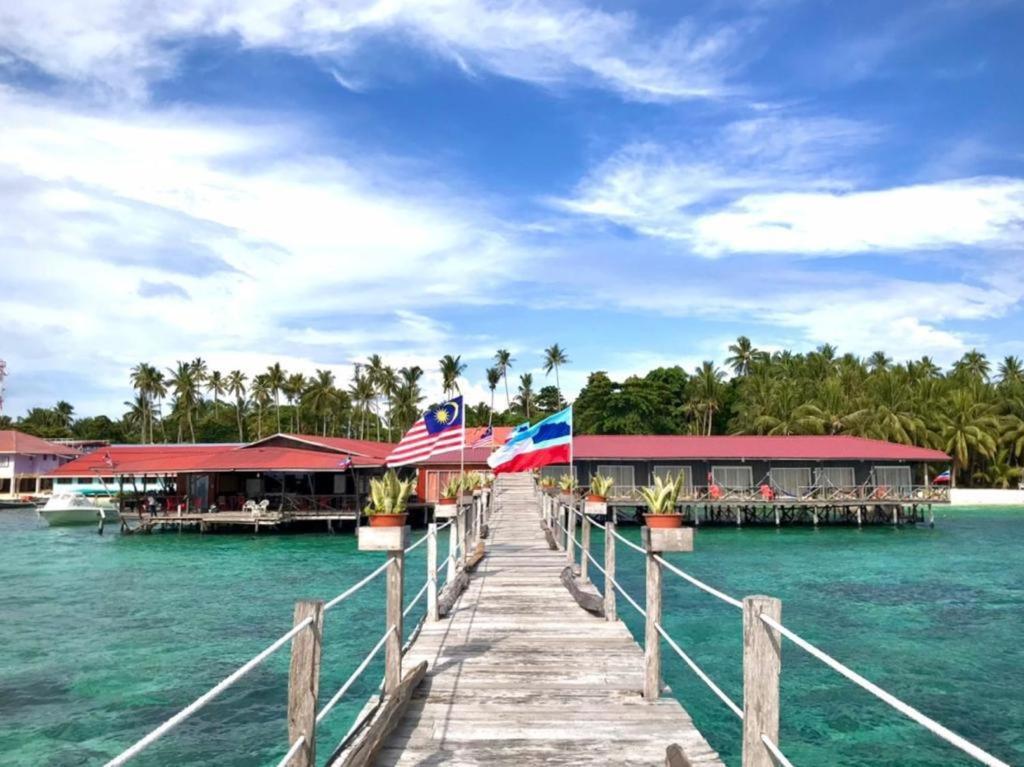 a dock with a restaurant on the water at Mabul Backpackers in Pulau Mabul 