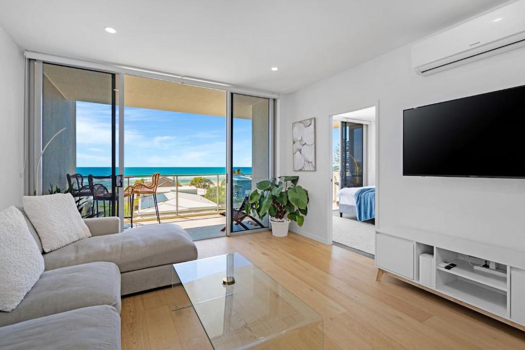a living room with a flat screen tv and a couch at Wave Watcher's Delight at Acqua Palm Beach in Gold Coast