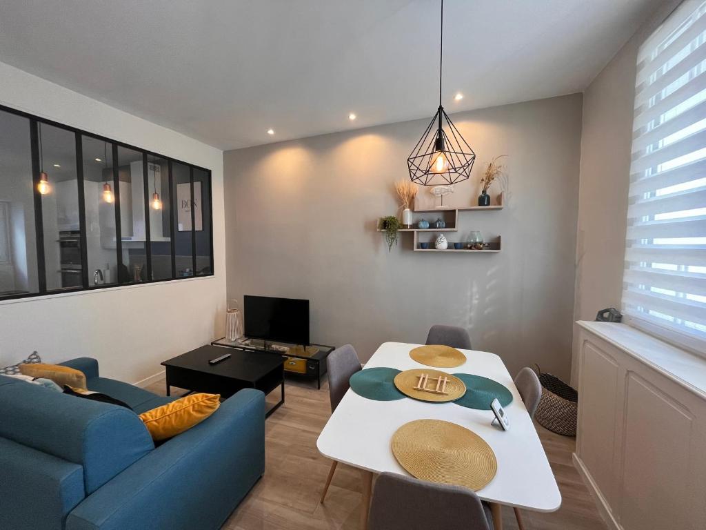 ein Wohnzimmer mit einem Tisch und einem blauen Sofa in der Unterkunft Maison Les Sables-d'Olonne, 3 pièces, 6 personnes - FR-1-197-557 in Les Sables-dʼOlonne