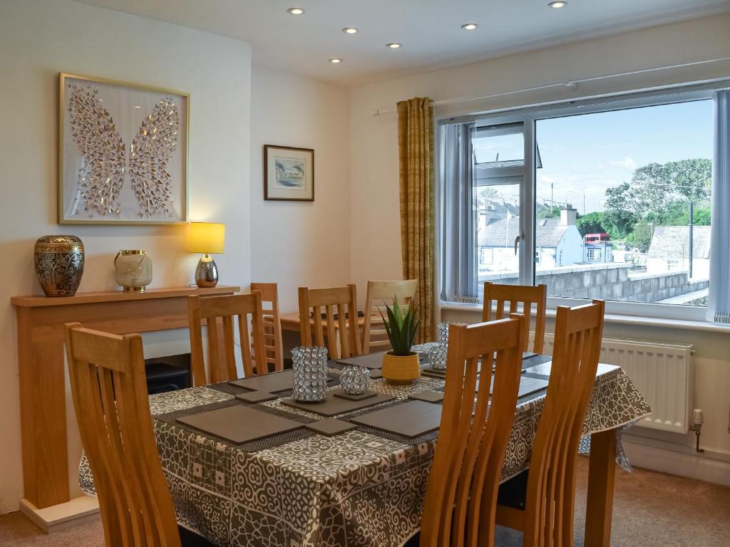 a dining room with a table and chairs and a window at Wylandre in Amlwch