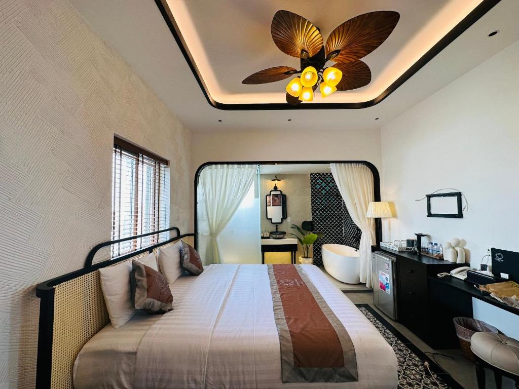 a bedroom with a bed with a ceiling fan at Phuong Nam Hotel An Giang in Long Xuyên