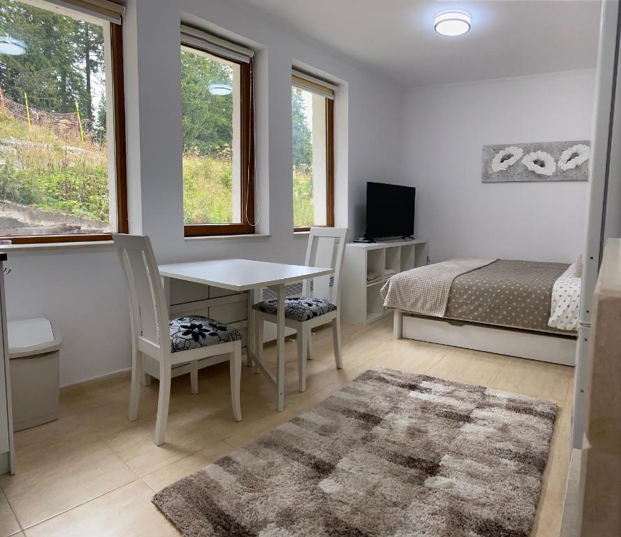 une chambre avec un lit, une table et des chaises dans l'établissement Ski in Ski out, Grand Monastery, Pamporovo, à Pamporovo