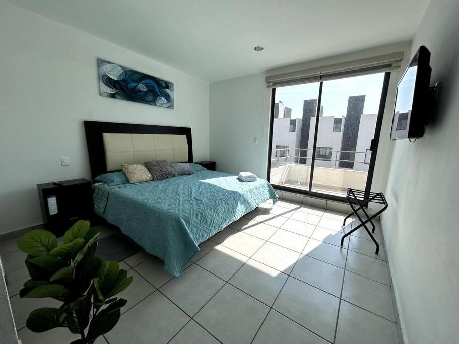 a bedroom with a bed and a large window at Casa completa en condominio privado con alberca in Miranda