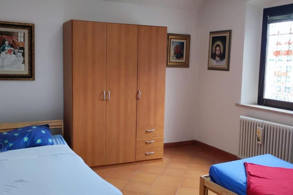 een slaapkamer met een houten kast en een bed bij Court of Artist Friuli in Sedegliano