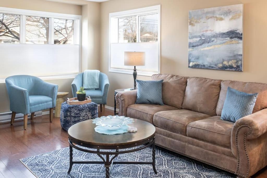a living room with a brown couch and chairs at Breezy Beach Villa near the Lake in Penticton