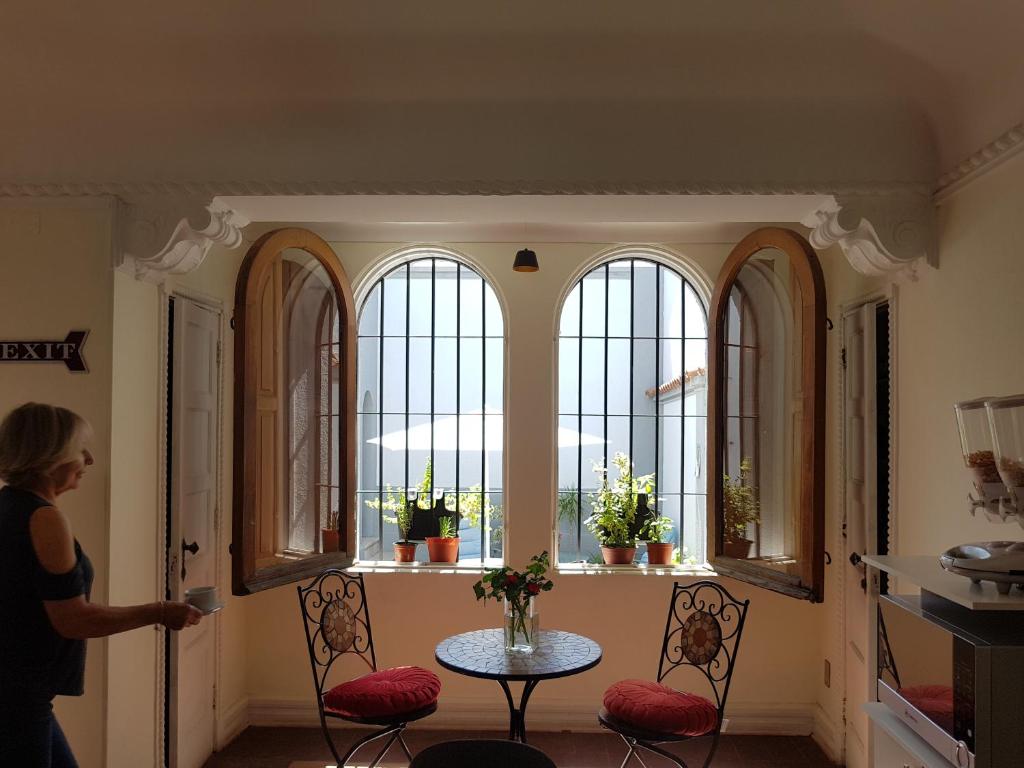 サンティアゴにあるHostal Boutique Casa La Barcaの四窓の部屋の扉を開ける女性
