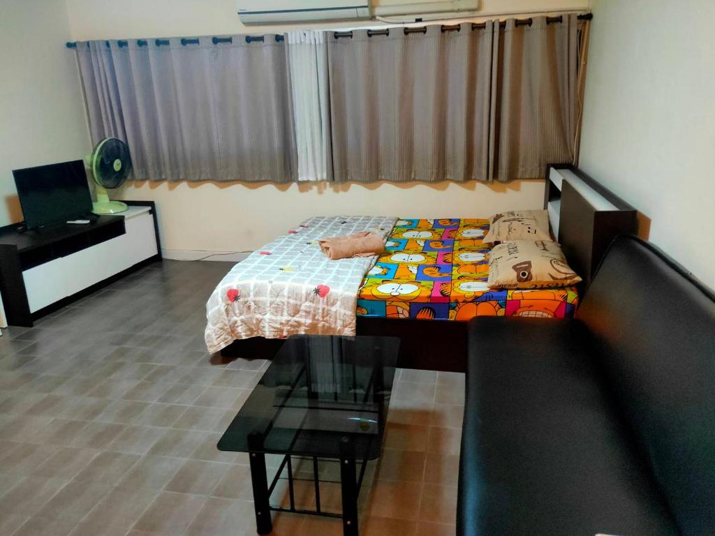 Dormitorio pequeño con cama y mesa en ป็อปปูล่าคอนโด เมืองทองใกล้อิมแพค สะดวกสบาย en Ban Bang Phang