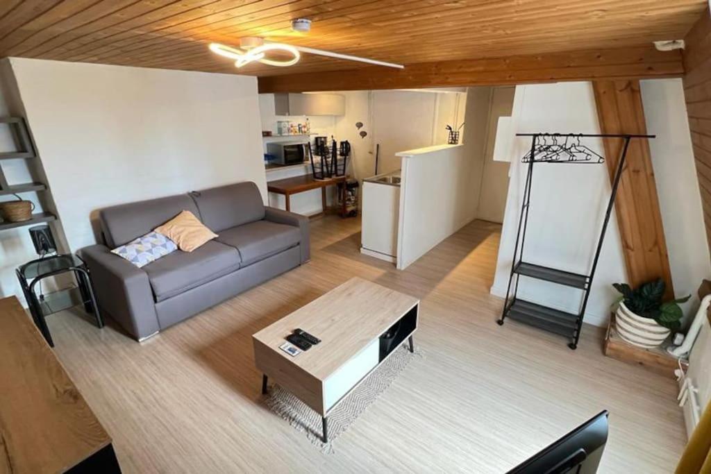 ein Wohnzimmer mit einem Sofa und einem Couchtisch in der Unterkunft Studio SUN - Hyper Centre Dunkerque & Proche Plage '15m in Dunkerque