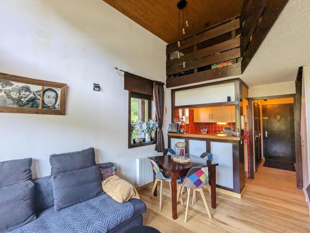 un salon avec un canapé bleu et une table dans l'établissement Duplex cosy 6 pers avec 2 balcons & parking à La Clusaz - FR-1-459-214, à La Clusaz