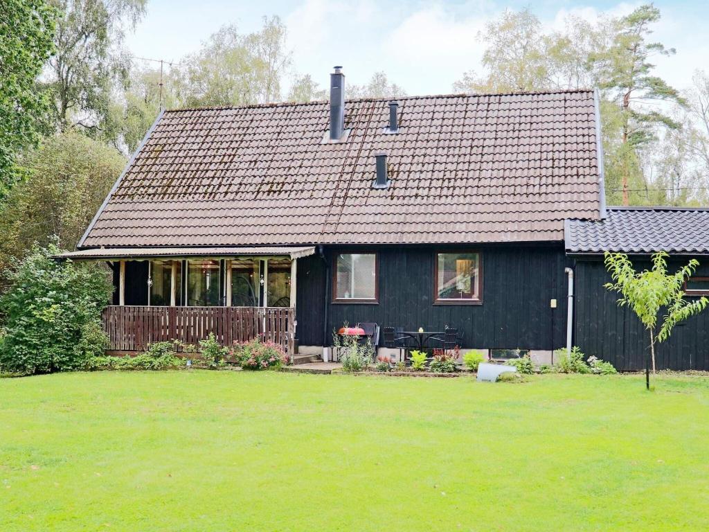 een zwart huis met een grote tuin ervoor bij Holiday home ULLARED III in Ullared