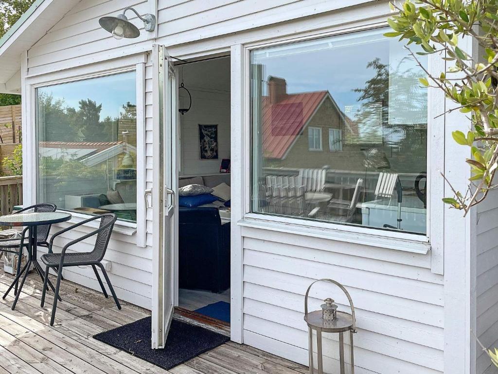 een afgeschermde veranda met een tafel en een glazen deur bij Holiday home SÖLVESBORG XIII in Sölvesborg