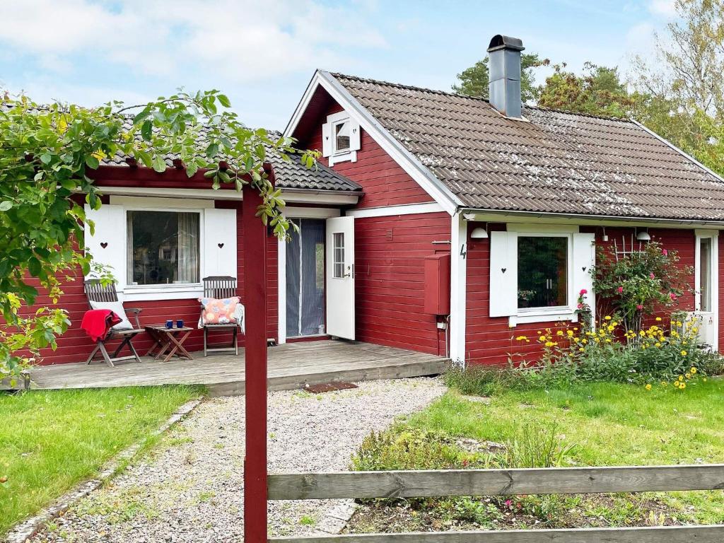 uma casa vermelha e branca com um alpendre em Holiday home RONNEBY XI em Ronneby