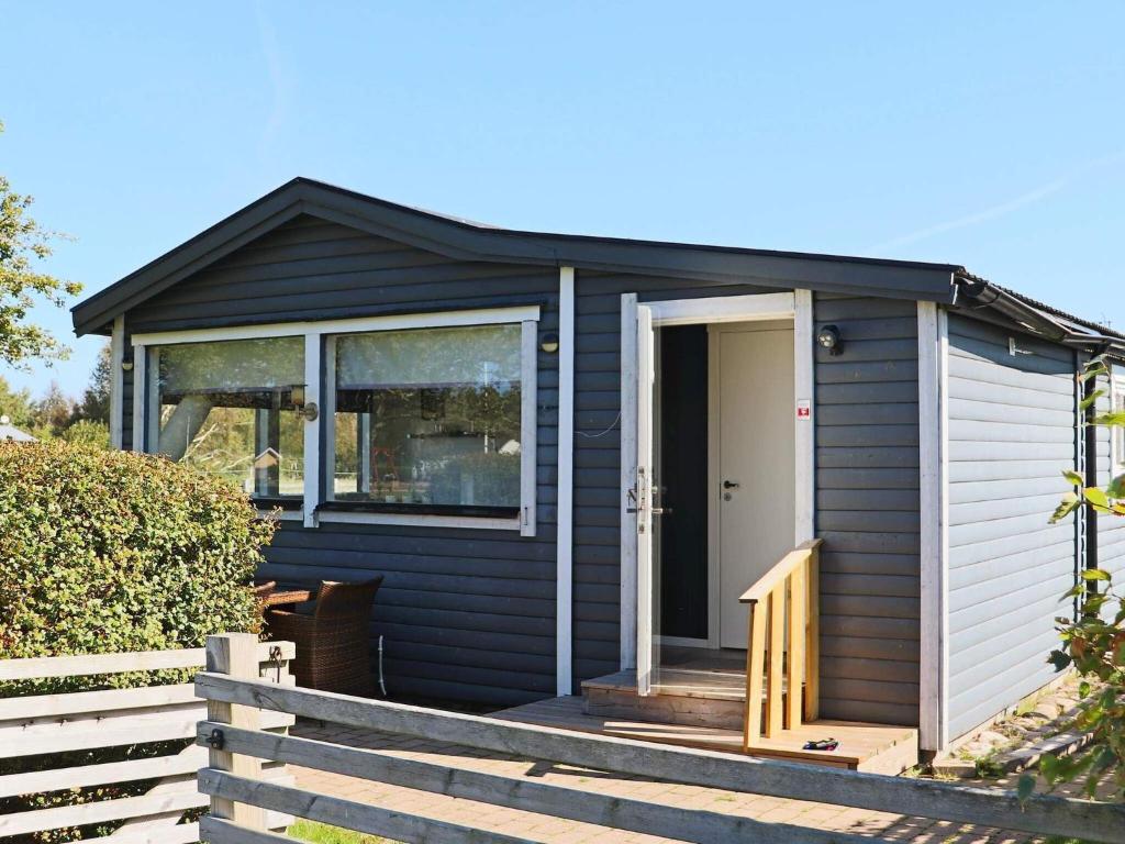 einen blauen Schuppen mit einer Veranda und einer Tür in der Unterkunft Holiday home LAHOLM in Laholm