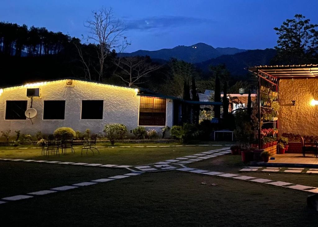 ein Haus in der Nacht mit eingeschaltetem Licht in der Unterkunft The Saraiville - Luxury Riverside Retreat, Cottages and Villas in Dehradun
