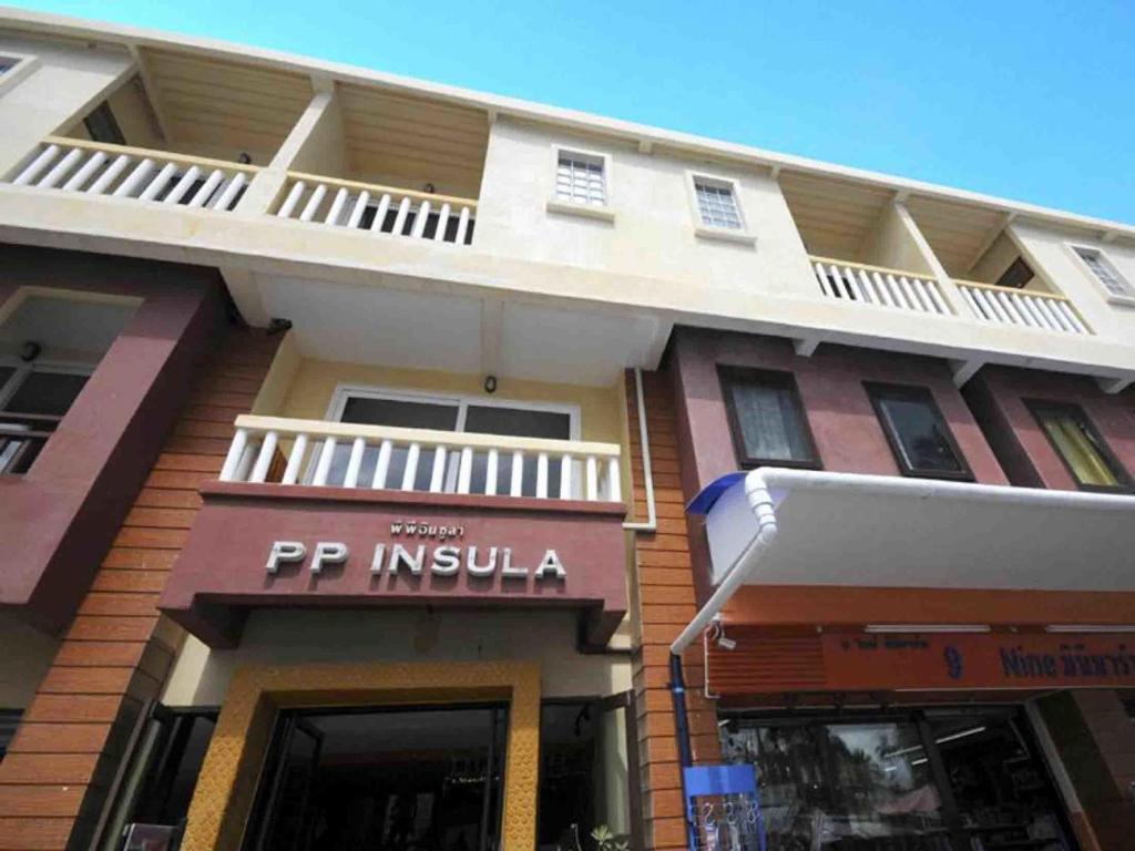 a building with a sign on the side of it at PP Insula in Phi Phi Islands