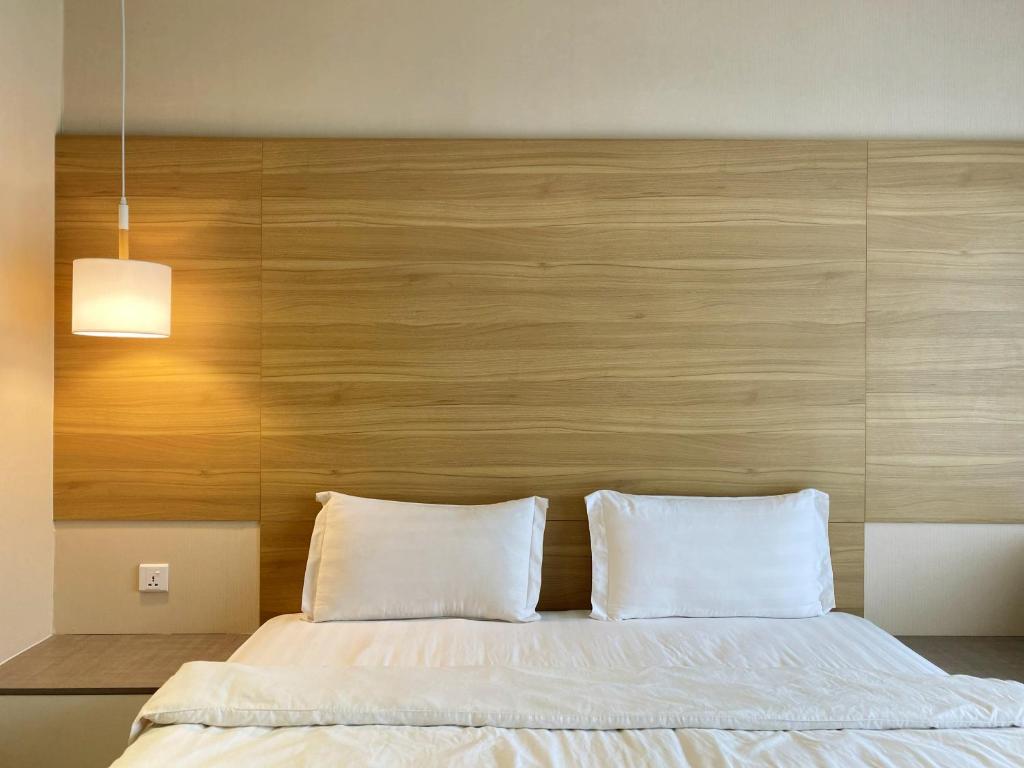 亞庇的住宿－Aeropod Cactus Rail Suite With Balcony - Kota Kinabalu，一间卧室配有一张大床和木制床头板