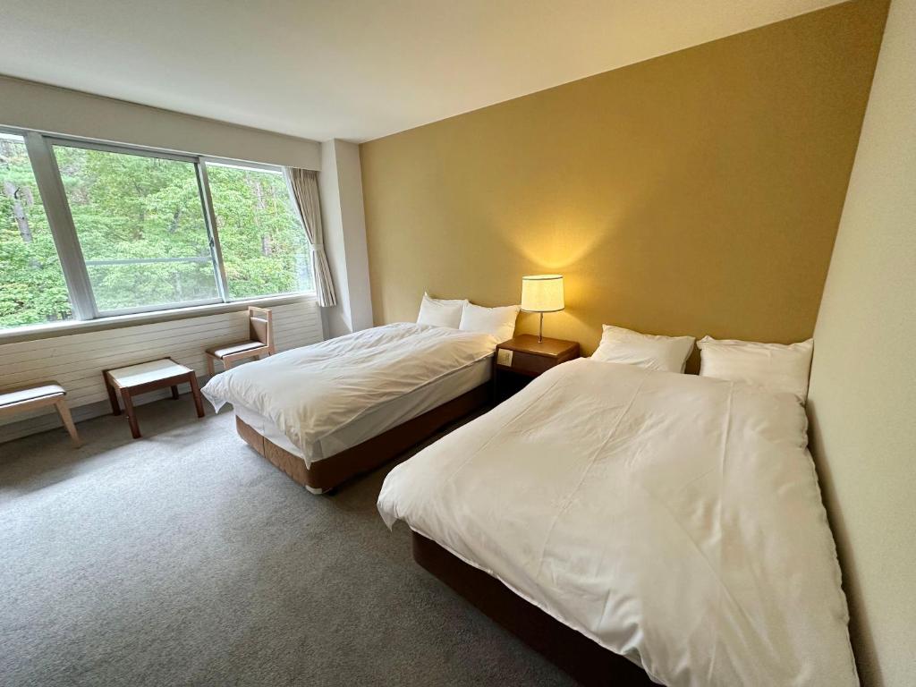 Postel nebo postele na pokoji v ubytování 北軽井沢　Golden Forest Hotel