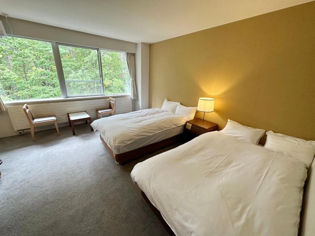 Postel nebo postele na pokoji v ubytování 北軽井沢　Golden Forest Hotel