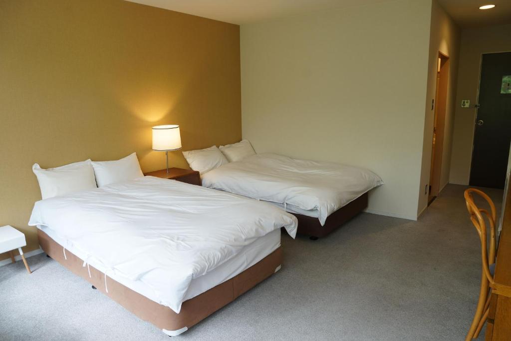 Postel nebo postele na pokoji v ubytování 北軽井沢　Golden Forest Hotel