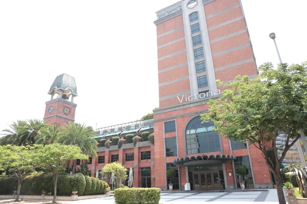 wysoki budynek z wieżą zegarową przed nim w obiekcie Grand Victoria Hotel w Tajpej