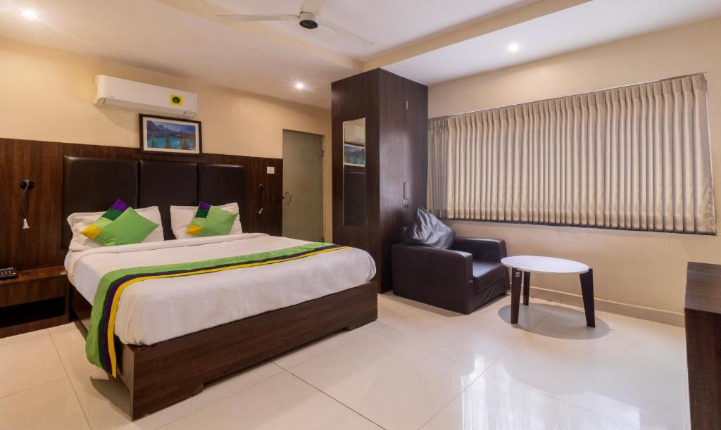 a hotel room with a bed and a chair at Treebo Trend Cool River in Visakhapatnam