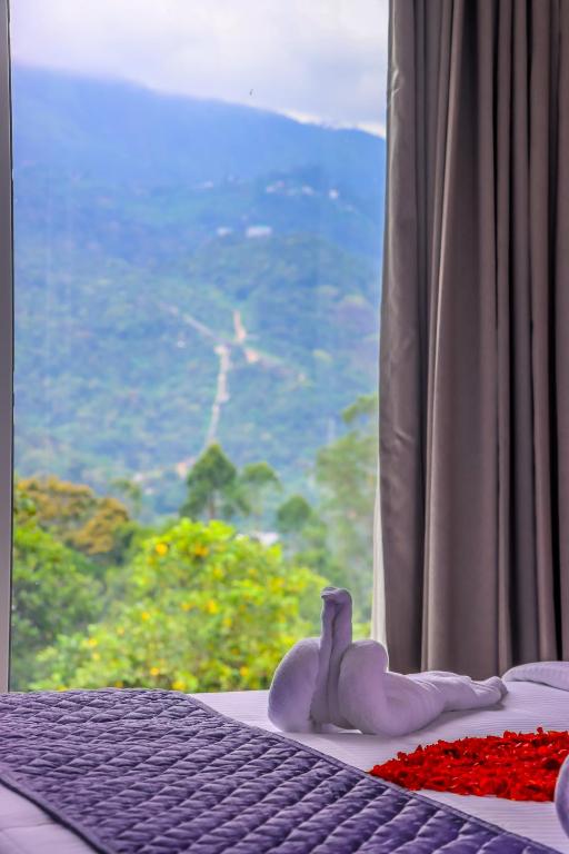 a bedroom with a bed and a window with a view at Winter Note Resorts in Munnar