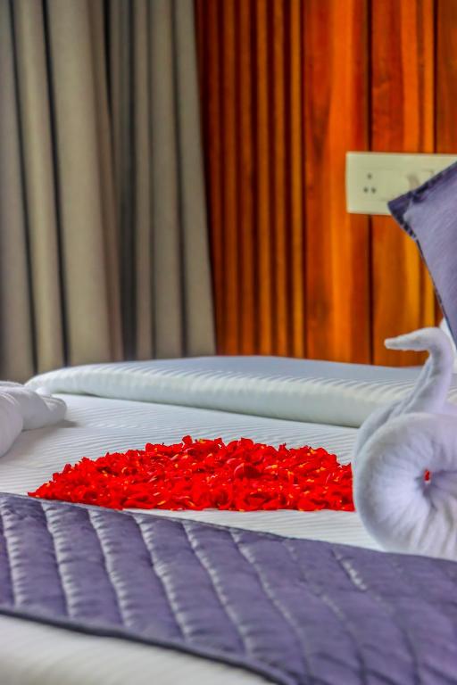 a bunch of beds with red roses on them at Winter Note Resorts in Munnar
