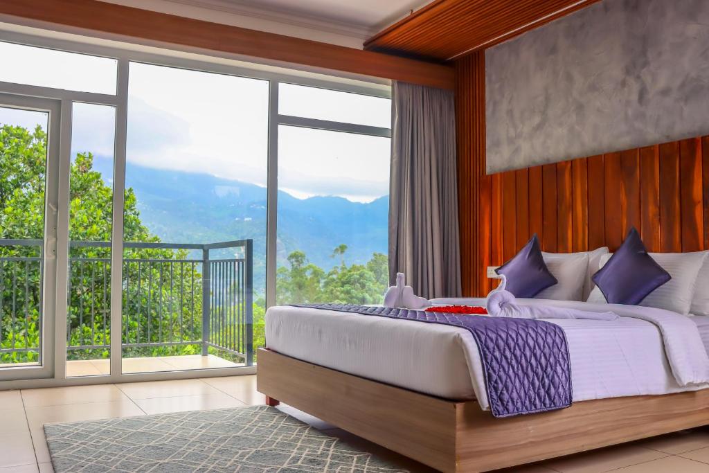 a bedroom with a large bed and large windows at Winter Note Resorts in Munnar