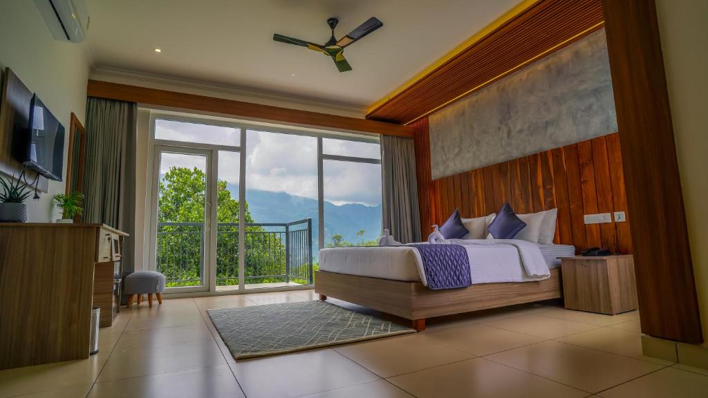 a bedroom with a bed and a large window at Winter Note Resorts in Munnar