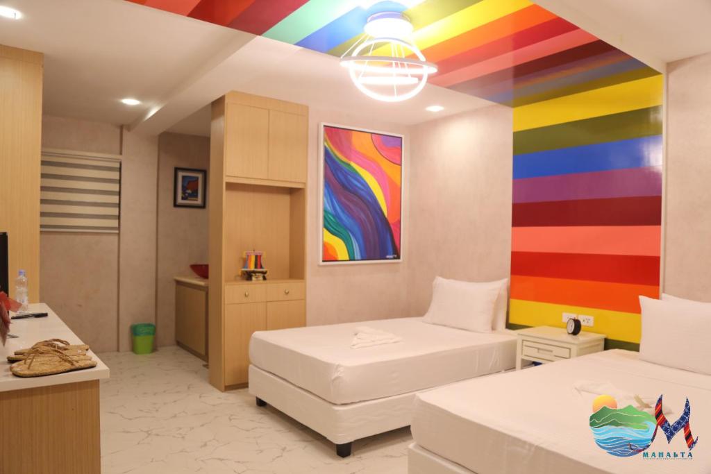Mahalta Resorts and Convention Center في Calapan: غرفة بها لوحة قوس قزح على الحائط