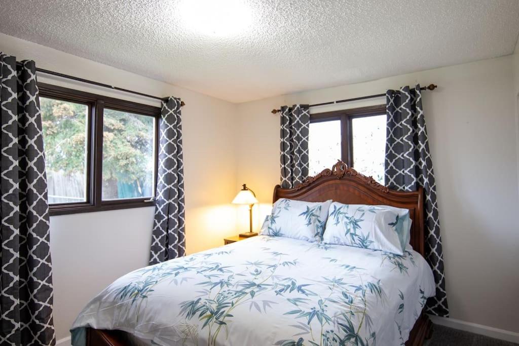 a bedroom with a bed and two windows at Spenard Guest House - The Bamboo Room in Anchorage