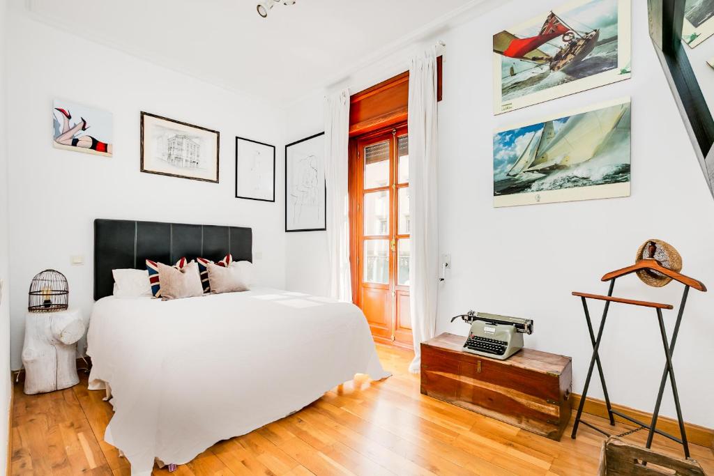een witte slaapkamer met een groot bed en een tafel bij Luxury apartment around Serrano and Juan Bravo in Madrid