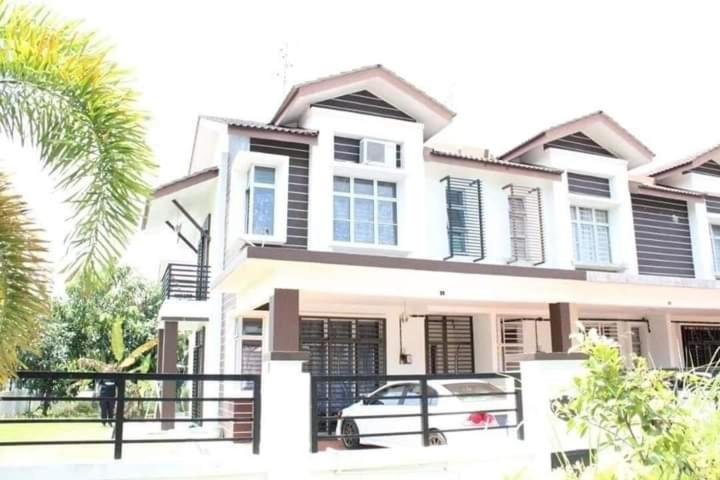 a house with a car parked in front of it at Abang payung sierra perdana in Masai