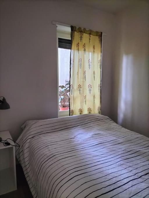ein Schlafzimmer mit einem Bett und einem Fenster mit einem Vorhang in der Unterkunft Villa Mirabella, il bosco in Città. in Turin